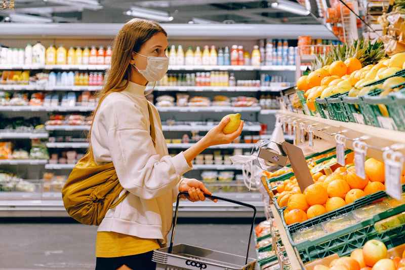 Una donna acquista dei limoni freschi al supermercato