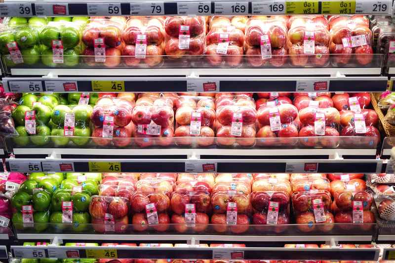 Confezioni di frutta e verdura fresche nel banco frigo del supermercato.