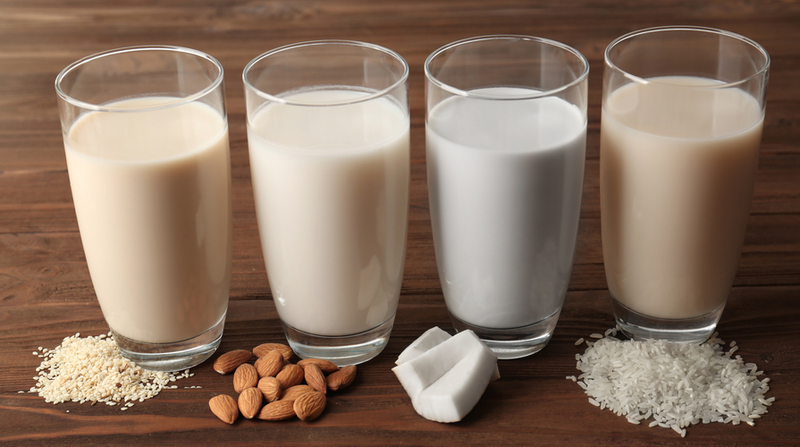 Quattro bicchieri di latte vegetale ricavato da soia, mandorle, cocco e riso.