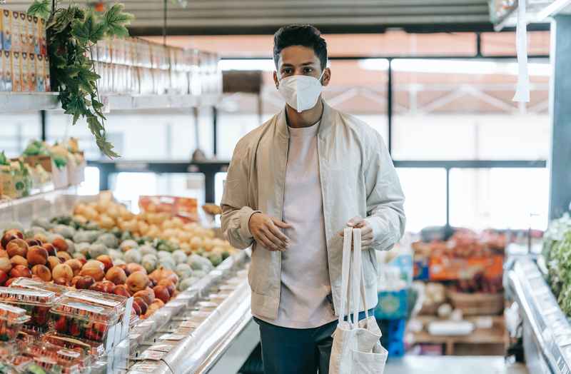 Un ragazzo fa la spesa al supermercato con una shopper riciclata.