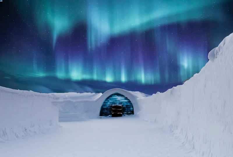 Paesaggio nordico innevato con l'Autora Borale nel cielo.